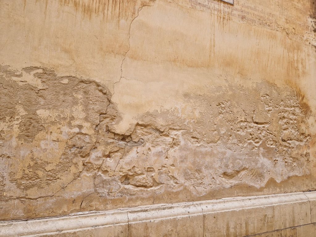 Vista de un muro de iglesia con problemas de humedad por capilaridad